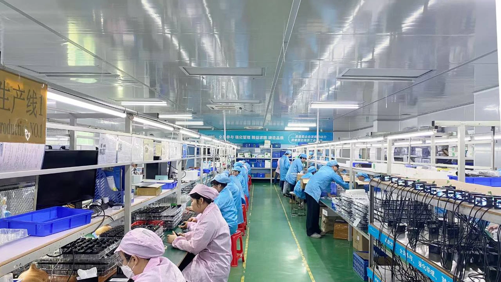 AUSEK camera production line with staff working at assembly stations