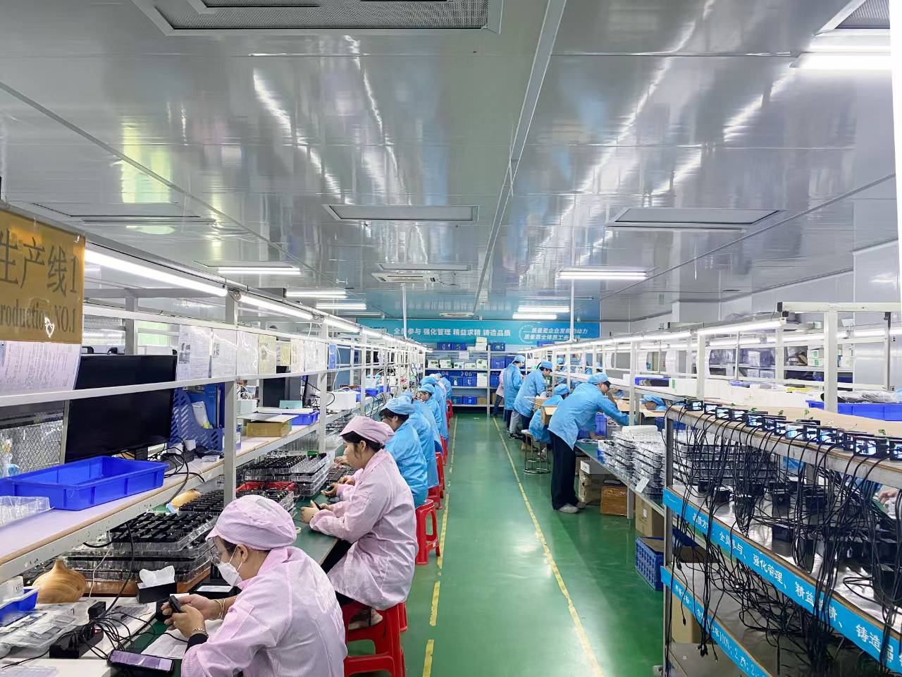 Company photo of AUSEK staff working at camera assembly stations